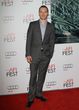Michael Fassbender con traje de chaqueta gris oscuro y camisa azul clara,  ¡guapísimo!